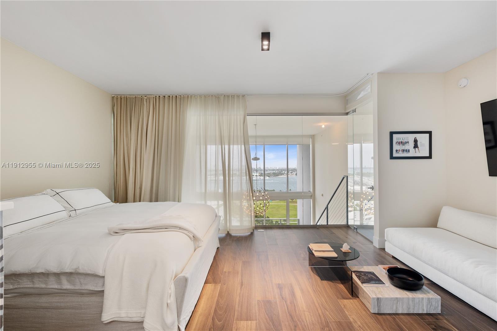 1040 Biscayne Boulevard, Unit 1602 Miami, FL 33132 - Photo 15 of 39 a bed room with a bed and a couch