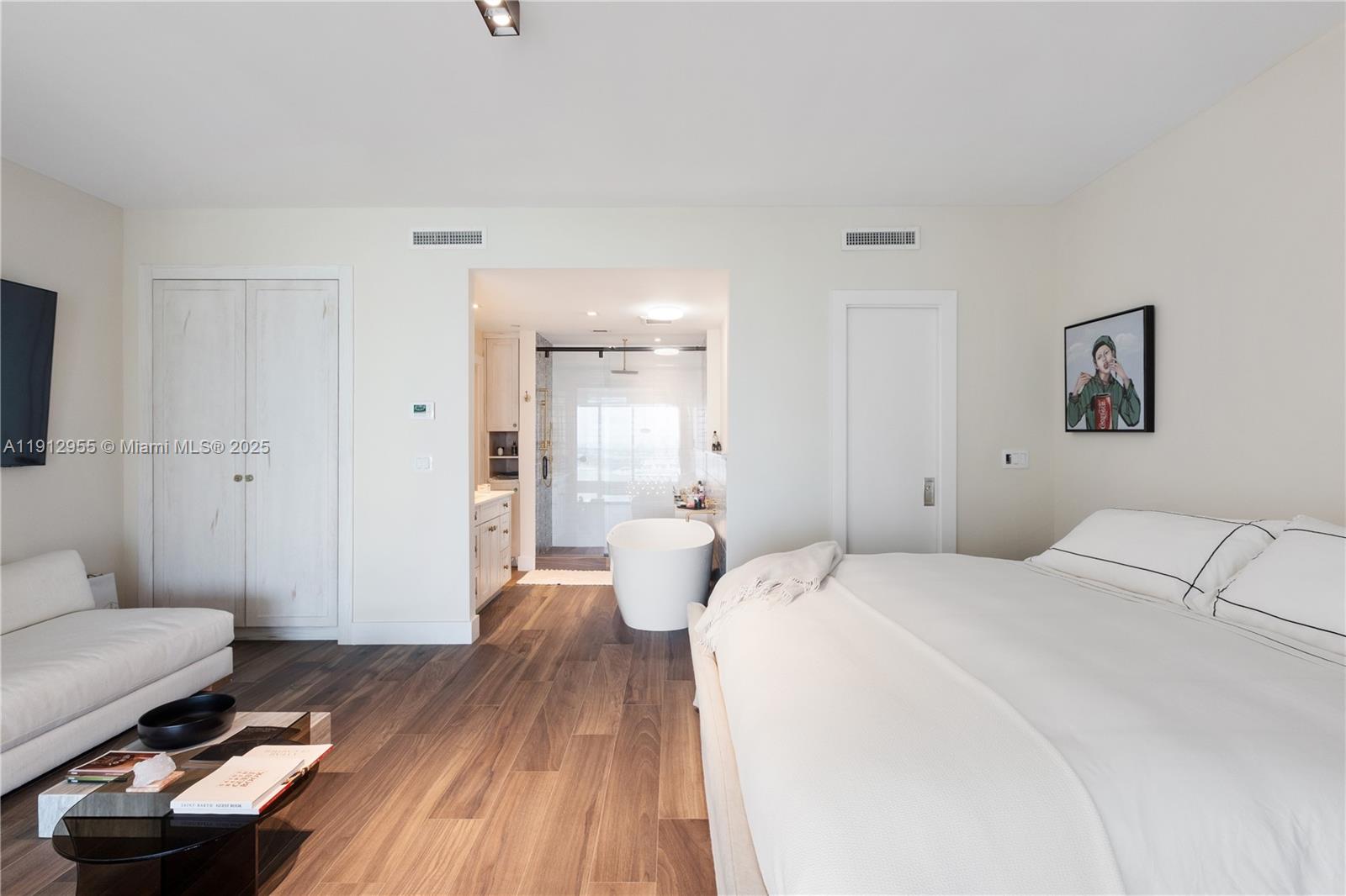 1040 Biscayne Boulevard, Unit 1602 Miami, FL 33132 - Photo 17 of 39 a bedroom with a bed and wooden floor