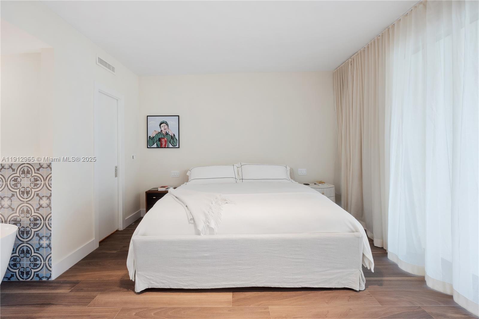 1040 Biscayne Boulevard, Unit 1602 Miami, FL 33132 - Photo 18 of 39 a bedroom with a bed and wooden floor