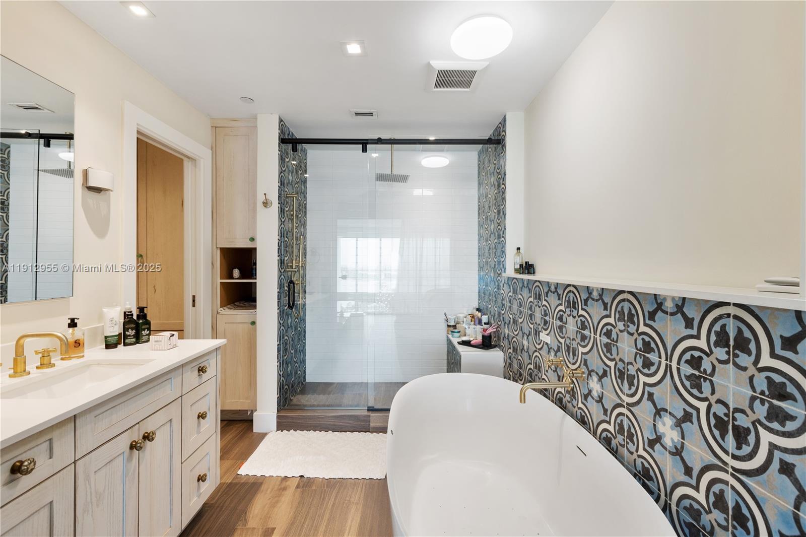 1040 Biscayne Boulevard, Unit 1602 Miami, FL 33132 - Photo 20 of 39 a bathroom with a bathtub sink mirror vanity and toilet