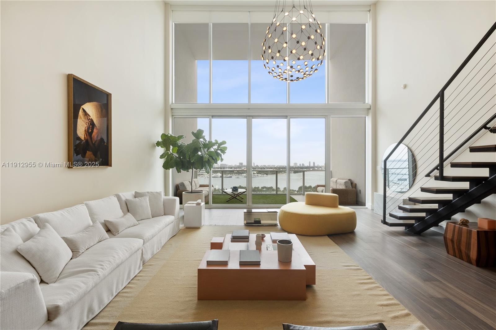 1040 Biscayne Boulevard, Unit 1602 Miami, FL 33132 - Photo 2 of 39 a living room with furniture and floor to ceiling windows