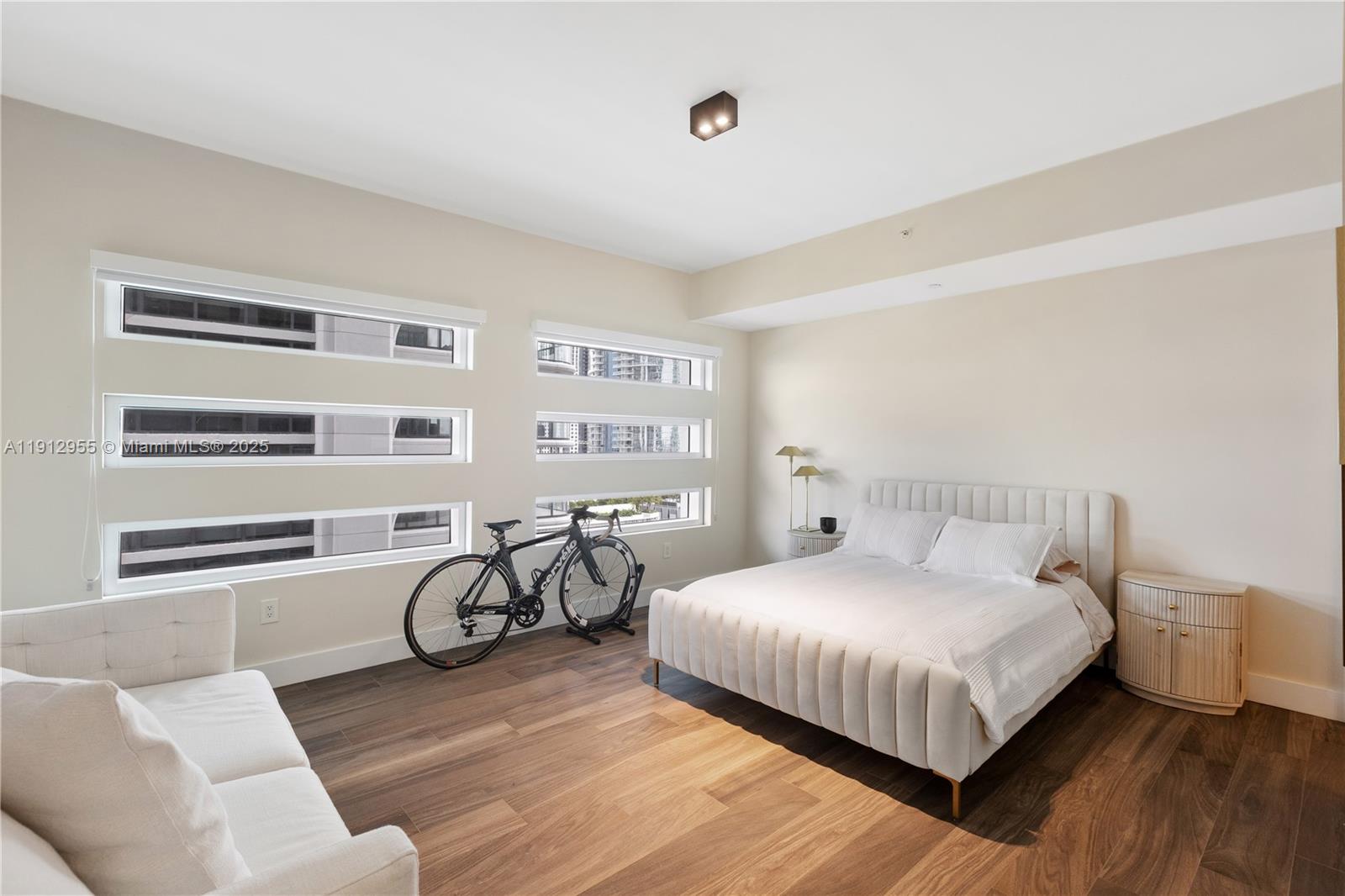 1040 Biscayne Boulevard, Unit 1602 Miami, FL 33132 - Photo 26 of 39 a bedroom with a bed and wooden floor