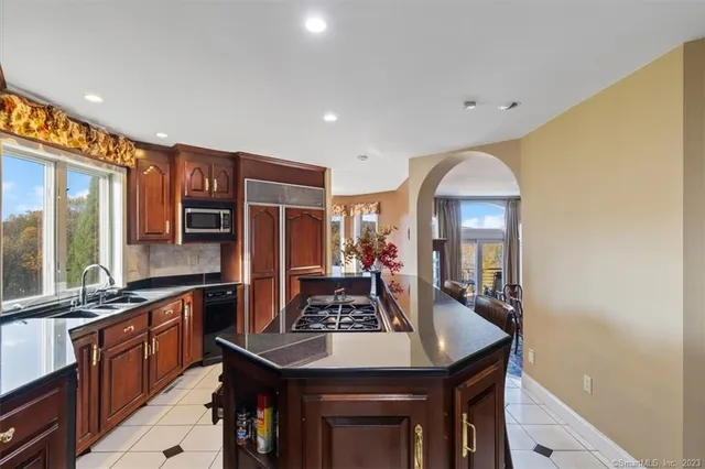 a kitchen with stainless steel appliances granite countertop a sink a stove and a refrigerator
