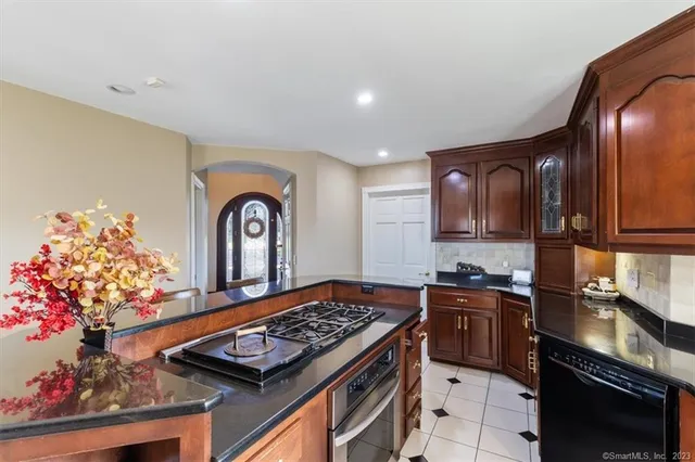 a kitchen with stainless steel appliances granite countertop a stove a sink and a refrigerator