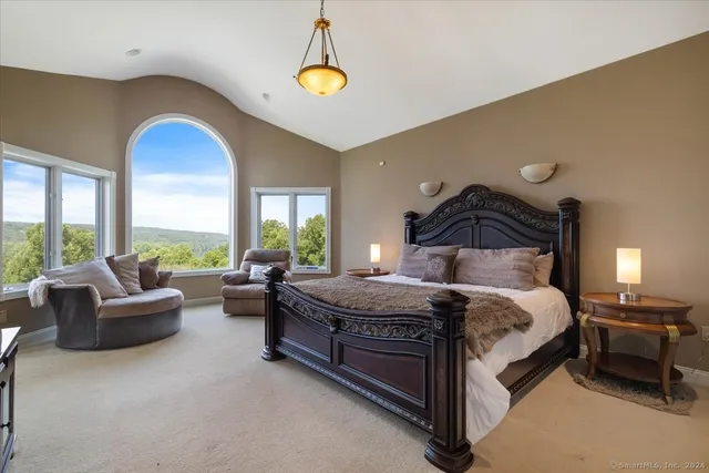 a bedroom with a bed and a large window