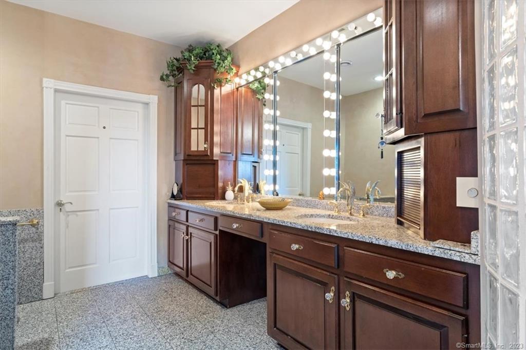 195 Injun Hollow Road Haddam, CT 06424 - Photo 28 of 40 a bathroom with a granite countertop sink a large mirror and a shower