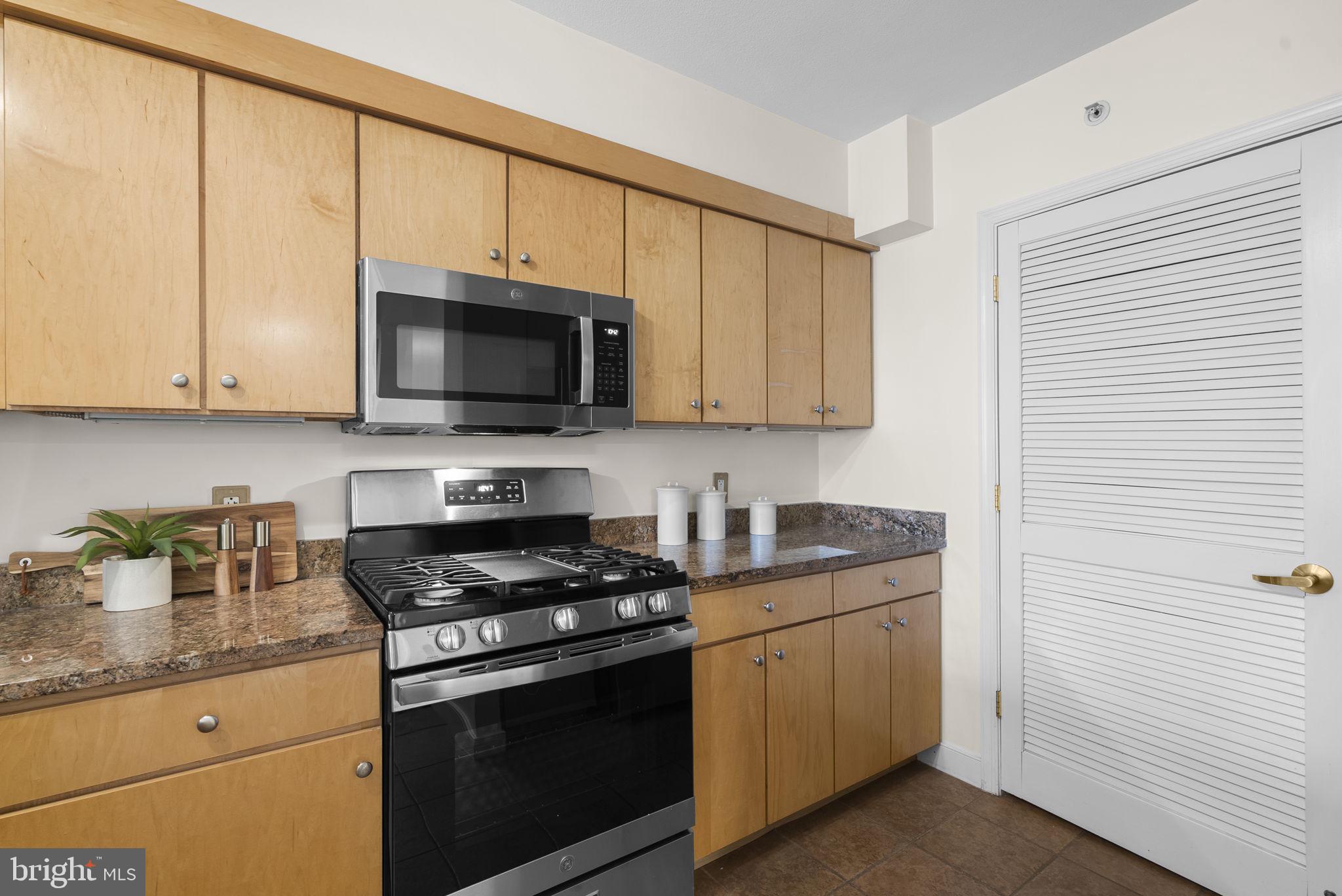 631 D Street Northwest, Unit 1129 Washington, DC 20004 - Photo 11 of 36 a kitchen with stainless steel appliances granite countertop white cabinets sink and a granite counter top
