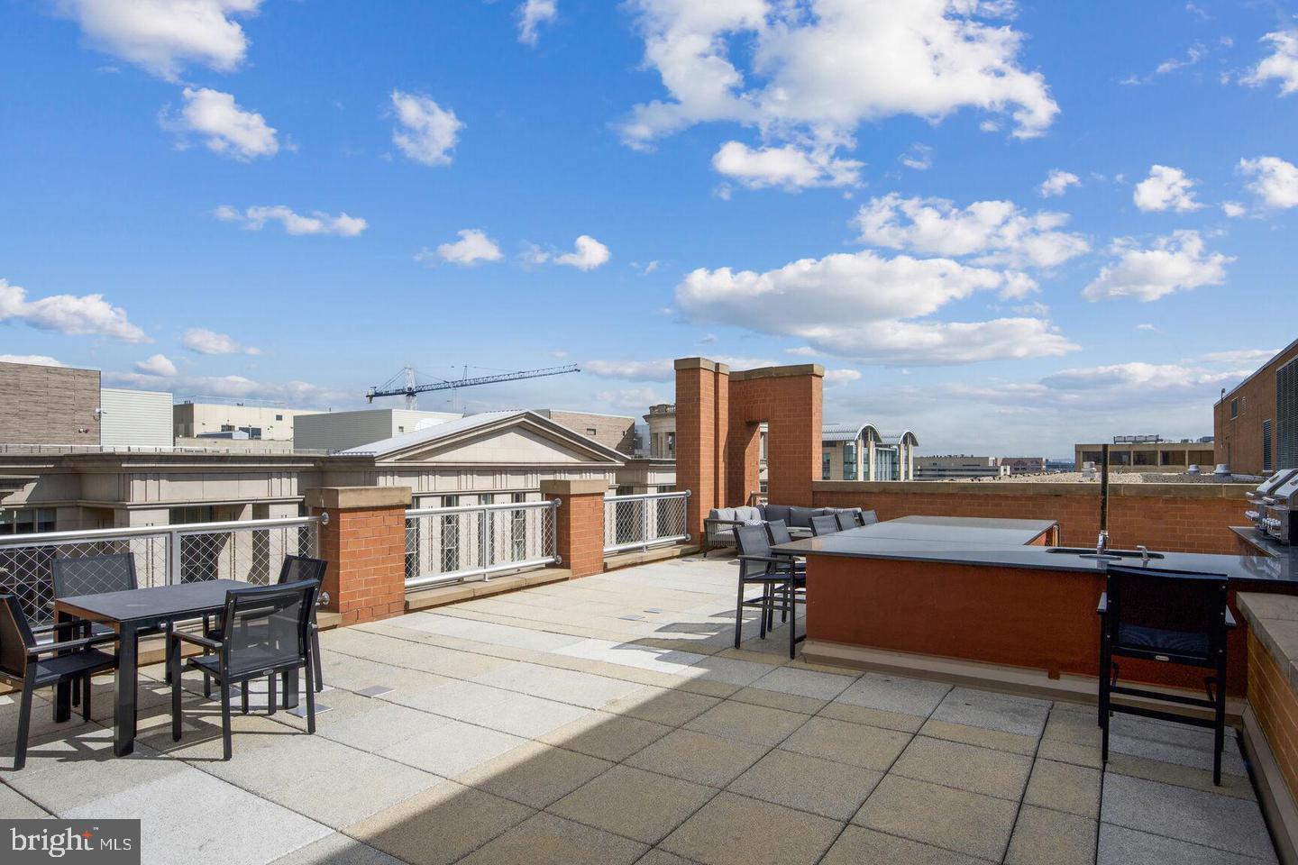 631 D Street Northwest, Unit 1129 Washington, DC 20004 - Photo 35 of 36 a roof deck with table and chairs