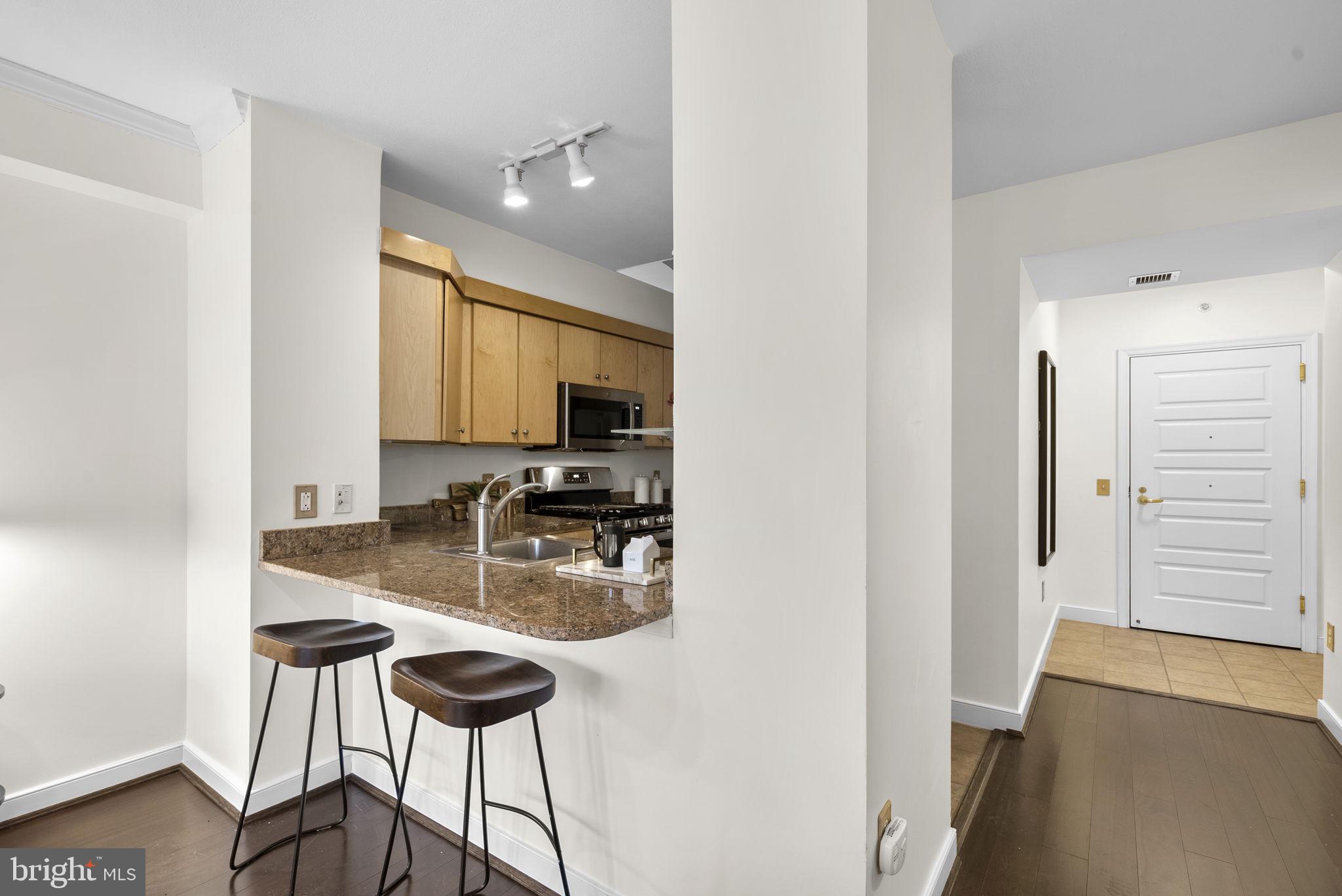 631 D Street Northwest, Unit 1129 Washington, DC 20004 - Photo 7 of 36 a kitchen with stainless steel appliances kitchen island a stove a sink and a refrigerator