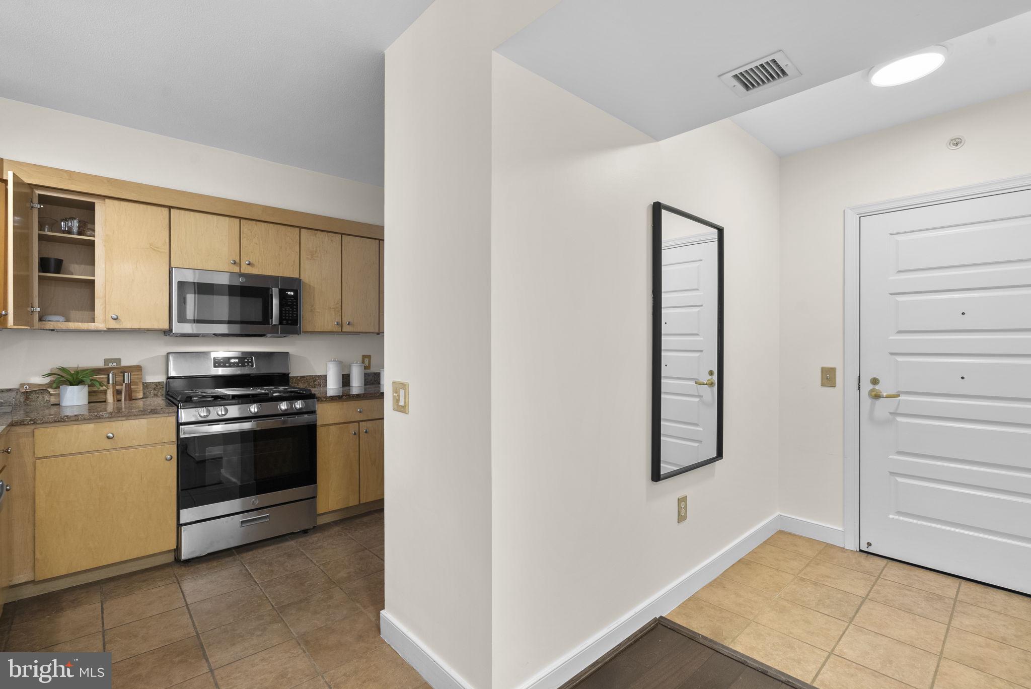 631 D Street Northwest, Unit 1129 Washington, DC 20004 - Photo 8 of 36 a kitchen with stainless steel appliances white cabinets and a stove top oven