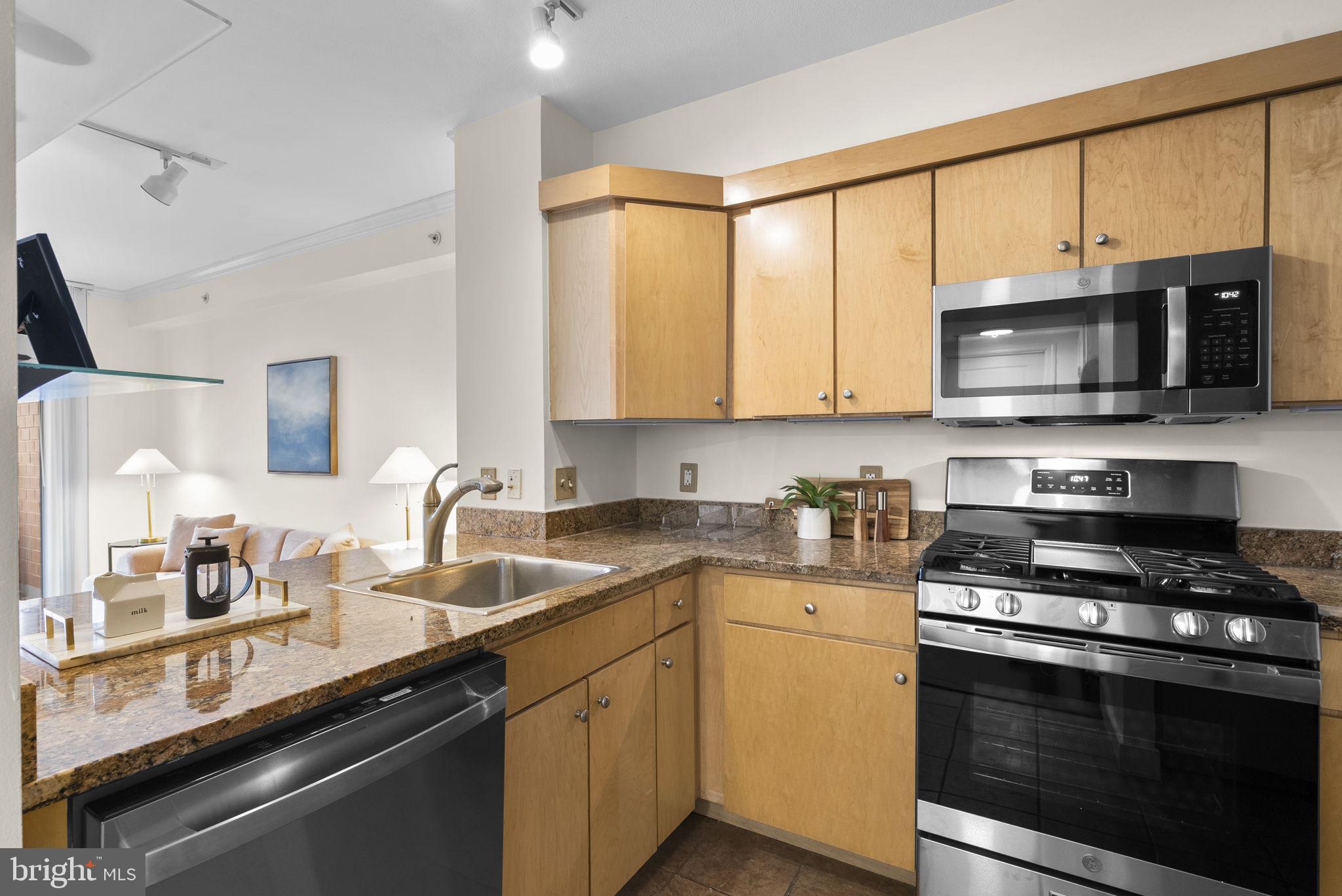 631 D Street Northwest, Unit 1129 Washington, DC 20004 - Photo 10 of 36 a kitchen with stainless steel appliances a stove a microwave sink and cabinets
