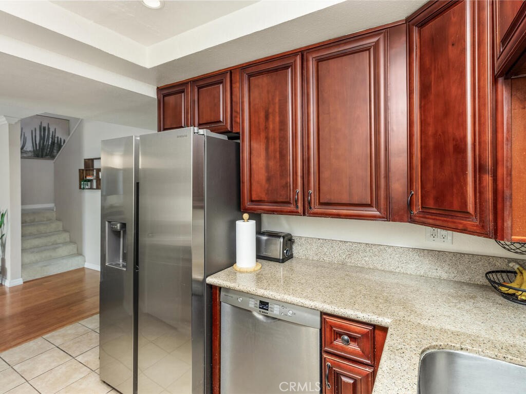 6907 Quail Place, Unit F Carlsbad, CA 92009 - Photo 7 of 23 a kitchen with stainless steel appliances granite countertop a refrigerator and a sink