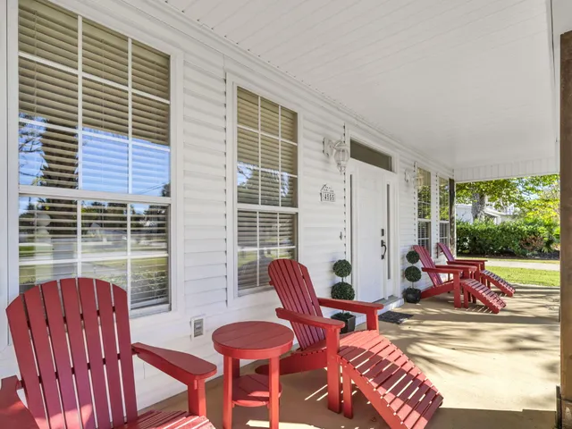 a view of a patio with table and chairs with wooden floor and plants