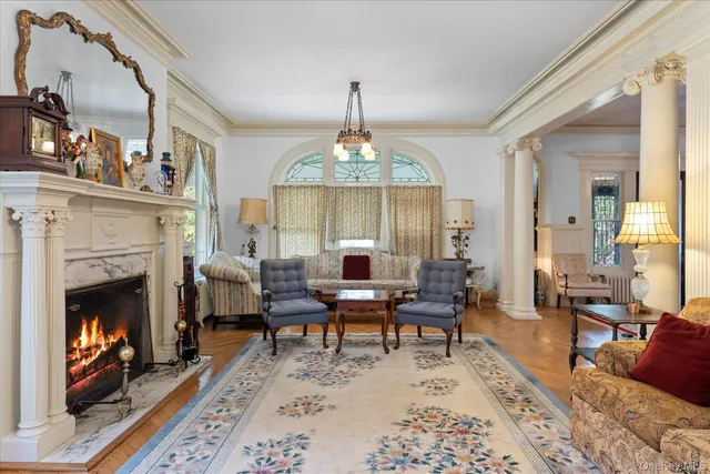 a living room with furniture a chandelier and a fireplace
