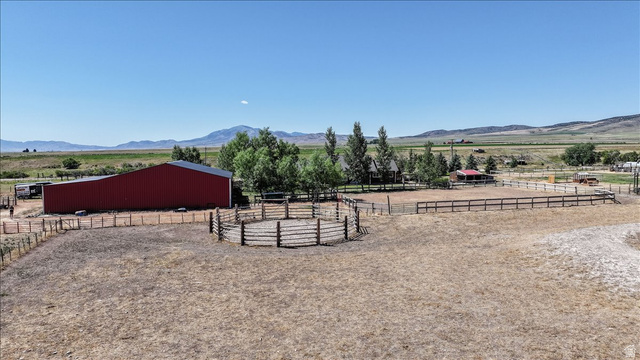 1634 West Arimo Road Arimo, ID 83214 - Photo 72 of 89 Expansive property featuring a large red barn with a metal roof, a round pen, and a rectangular fenced riding arena