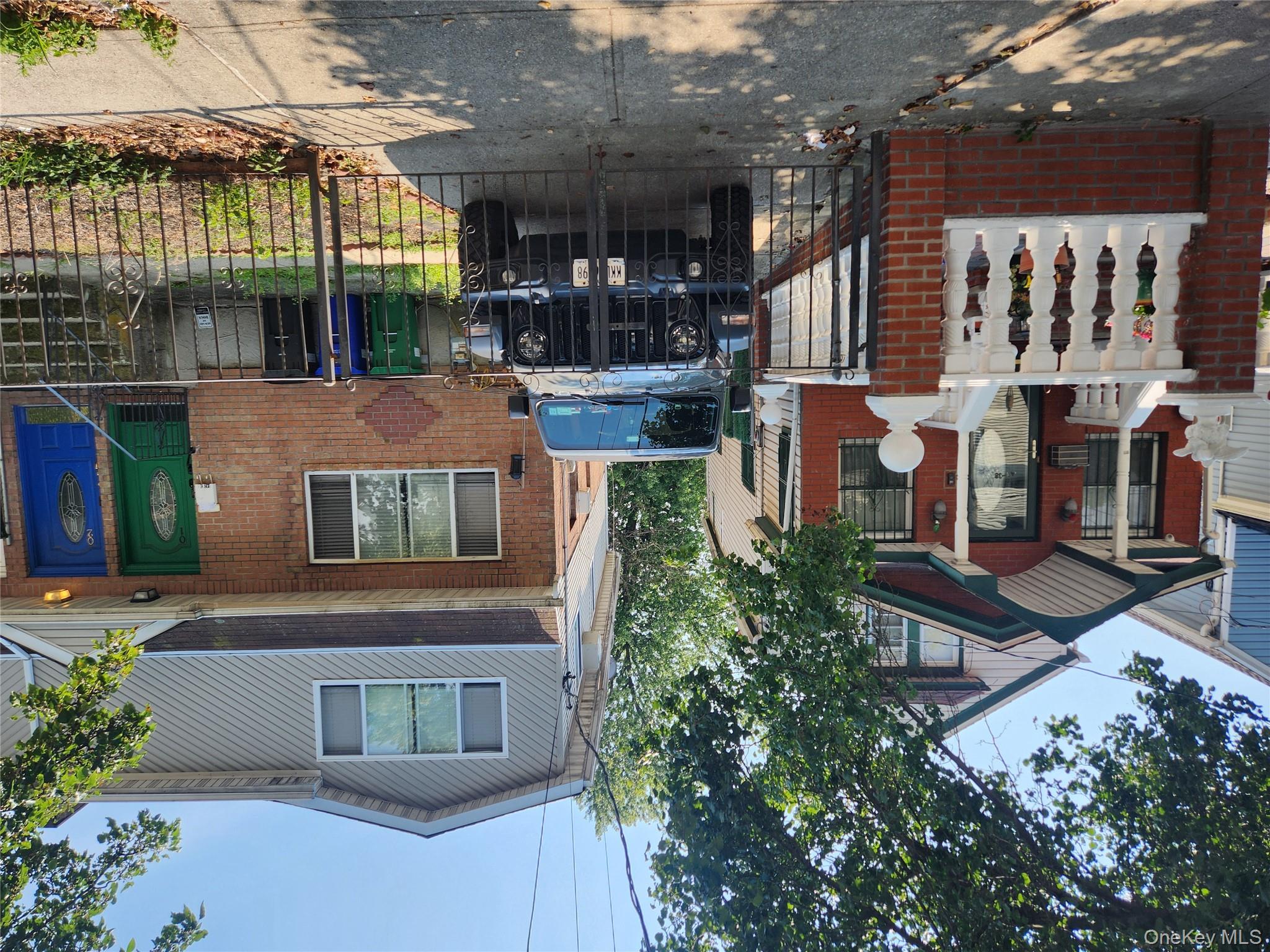 142-34 Bascom Avenue Queens, NY 11436 - Photo 2 of 21 View of front of house featuring brick siding, a gate, a fenced front yard, and a gambrel roof