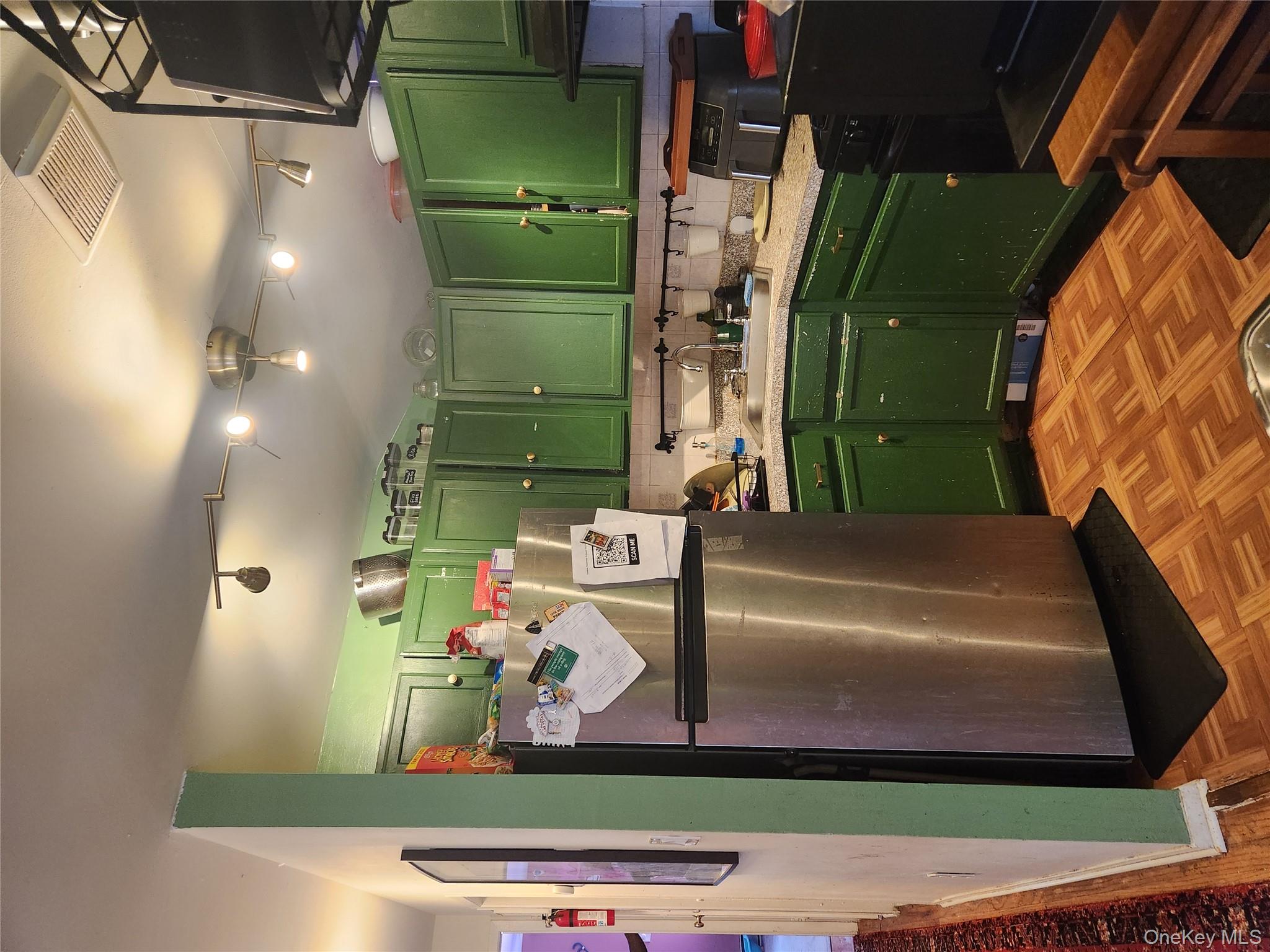 142-34 Bascom Avenue Queens, NY 11436 - Photo 3 of 21 Kitchen featuring green cabinetry, fridge, light countertops, decorative backsplash, and range hood