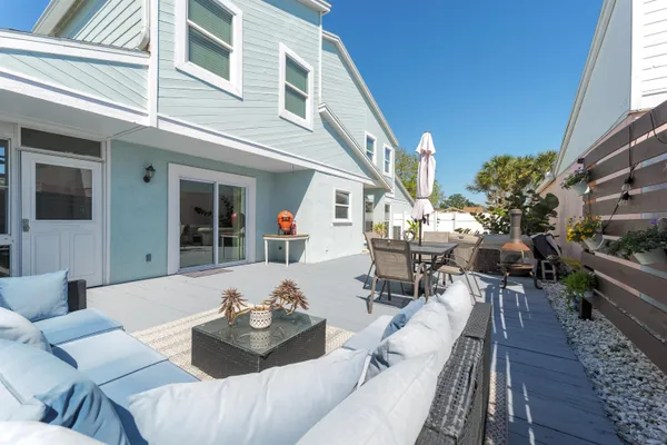 a view of a patio with couches table and chairs and potted plants