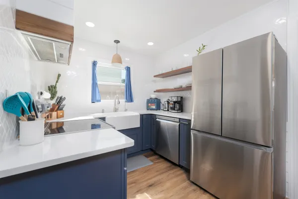 a kitchen with stainless steel appliances a refrigerator sink and white cabinets