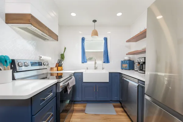 a kitchen with stainless steel appliances granite countertop a sink stove and refrigerator