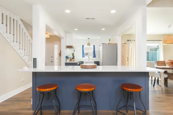 a kitchen with stainless steel appliances dining table and chairs