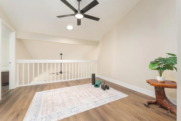 a very nice looking room with wooden floor and a ceiling fan