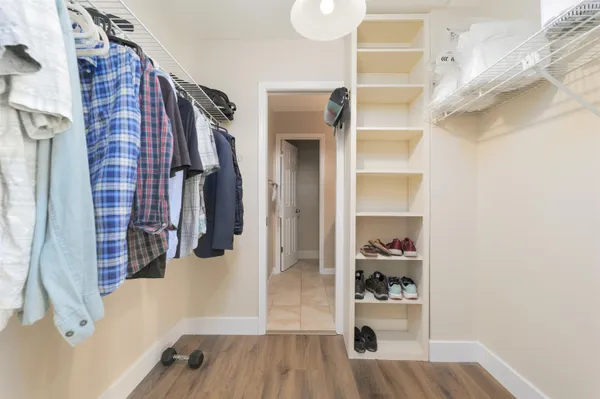 a view of walk in closet with clothes and shoes