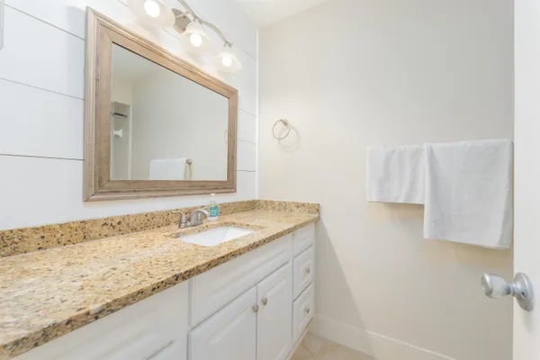 a bathroom with a granite countertop sink and a mirror