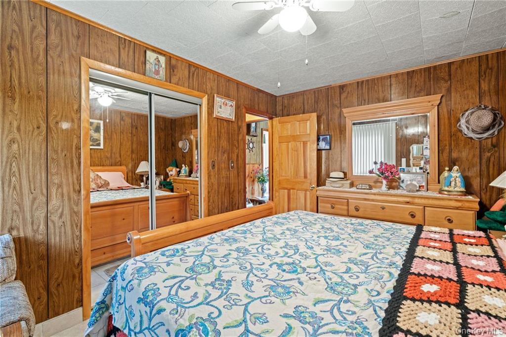 6 Leonard Road Monticello, NY 12701 - Photo 23 of 35 a bedroom with a bed and a large mirror with a flat tv screen