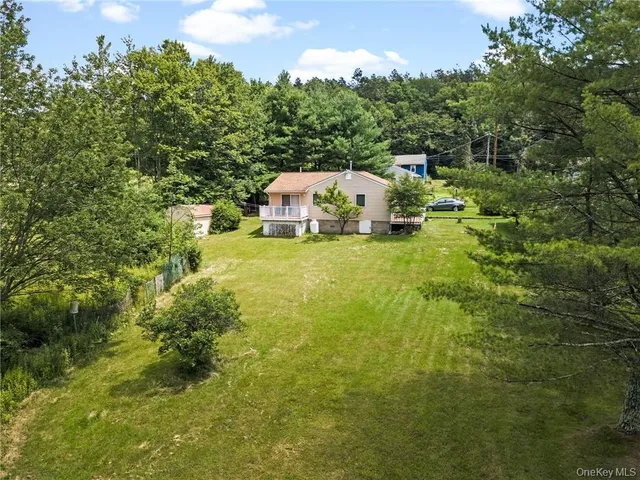 a view of a big yard with plants and large trees