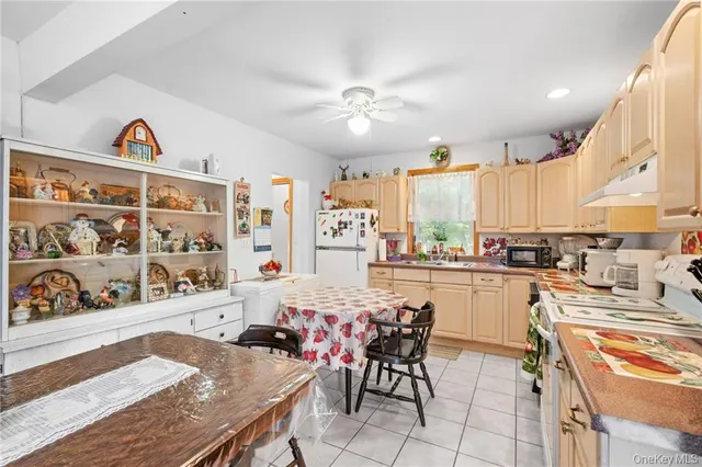 a kitchen with stainless steel appliances kitchen island granite countertop a table chairs in it and wooden floor