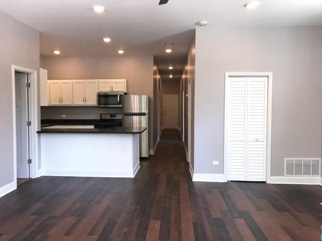 a view of kitchen with sink and refrigerator