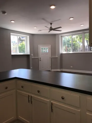 a kitchen with kitchen island a large window appliances and cabinets