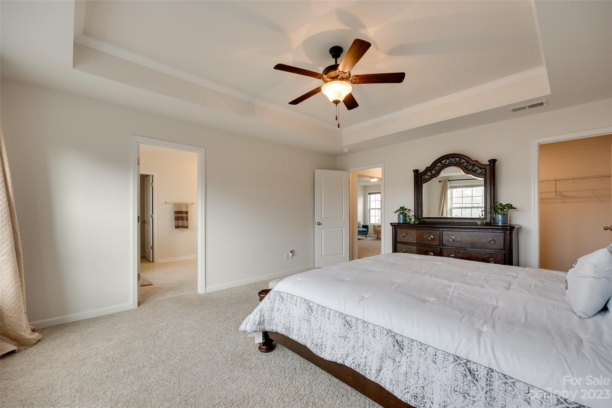 8013 Oakmere Road Waxhaw, NC 28173 - Photo 23 of 30 a bedroom with a large bed and a chandelier