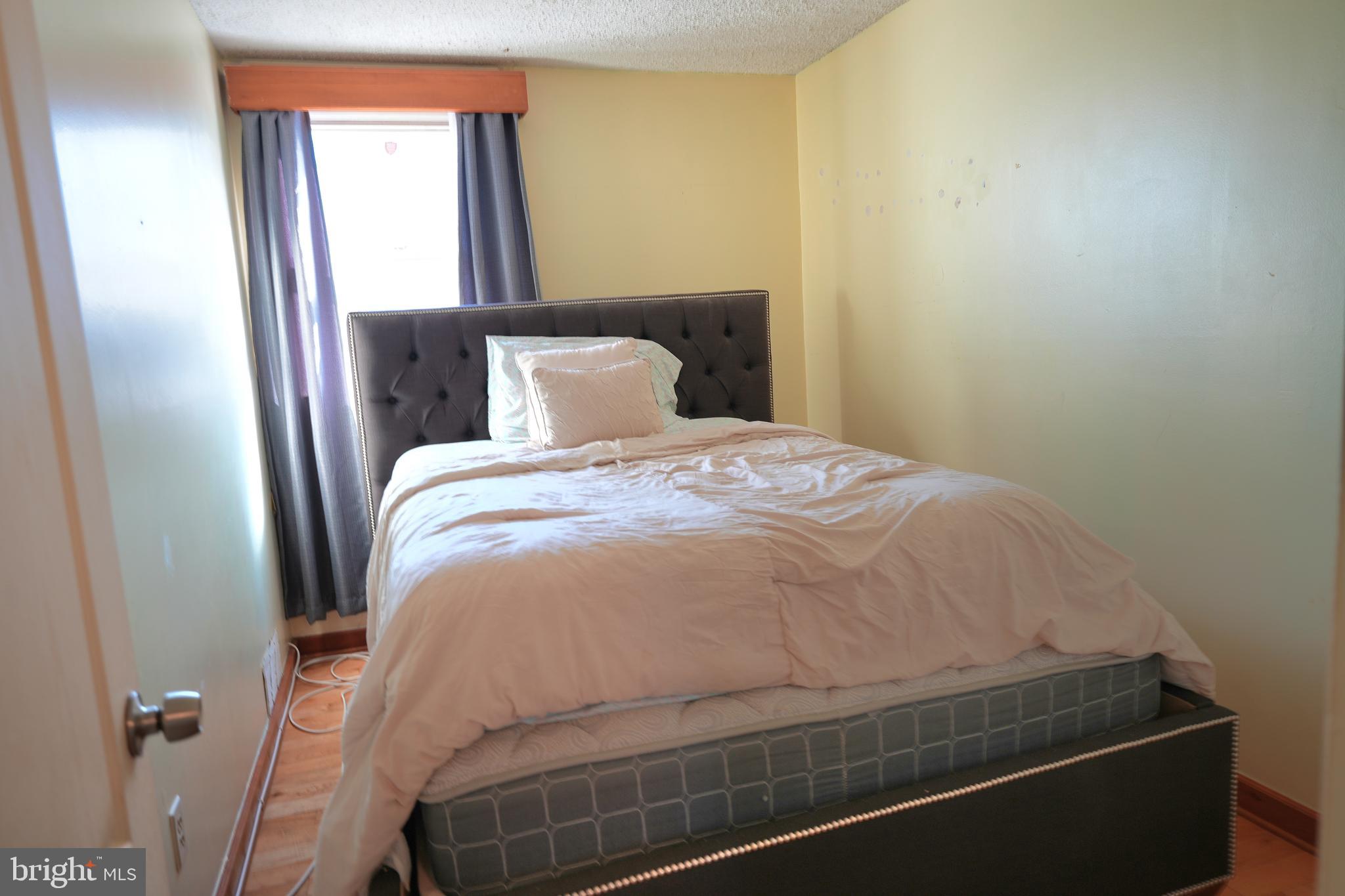 9274 Angus Place Philadelphia, PA 19114 - Photo 8 of 10 a bed sitting in a bedroom next to a window