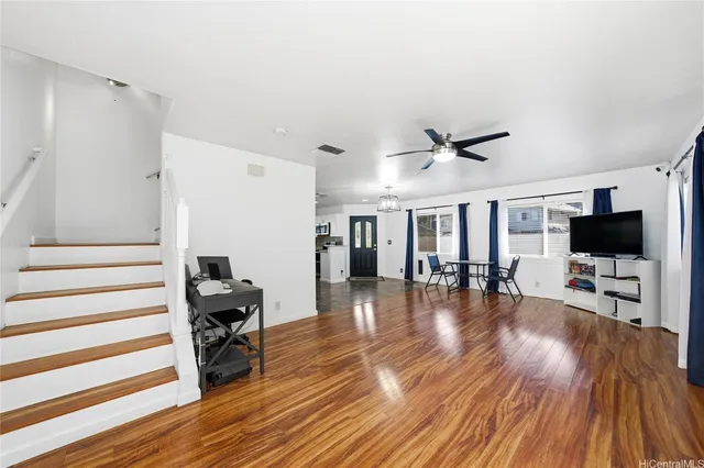 a view of a livingroom with wooden floor and a ceiling fan
