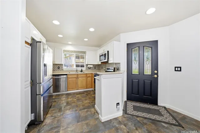 a kitchen with a refrigerator and white cabinets