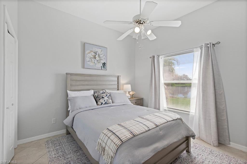 11774 Longshore Way West Naples, FL 34119 - Photo 16 of 35 a bedroom with a large bed and a chandelier