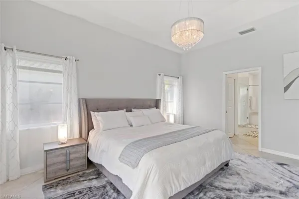 a bedroom with a bed and a chandelier