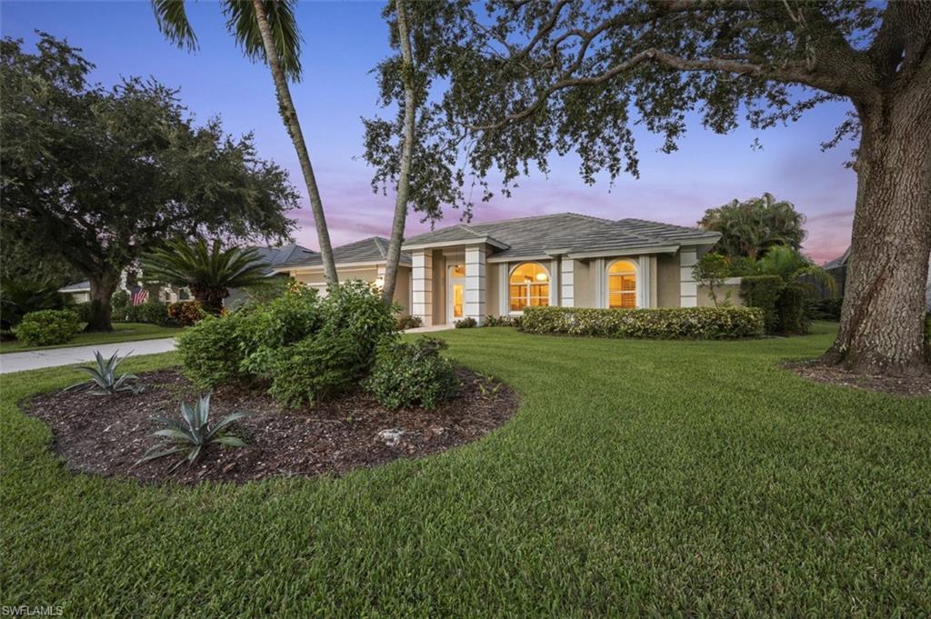 11774 Longshore Way West Naples, FL 34119 - Photo 2 of 35 a front view of a house with a garden