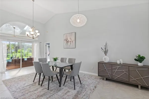 a view of a dining room with furniture a chandelier and wooden floor