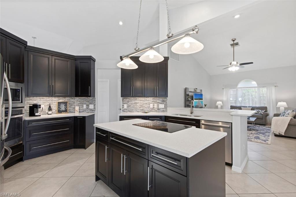 11774 Longshore Way West Naples, FL 34119 - Photo 7 of 35 a kitchen with a sink a stove and chairs