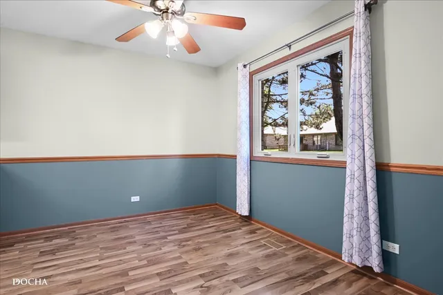 a view of a room with wooden floor and fan