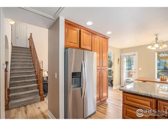 a kitchen view with granite countertop a refrigerator and a sink