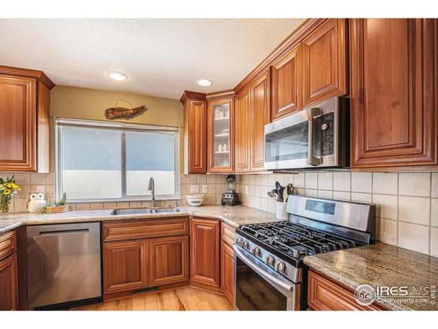 a kitchen with stainless steel appliances granite countertop a sink stove and cabinets