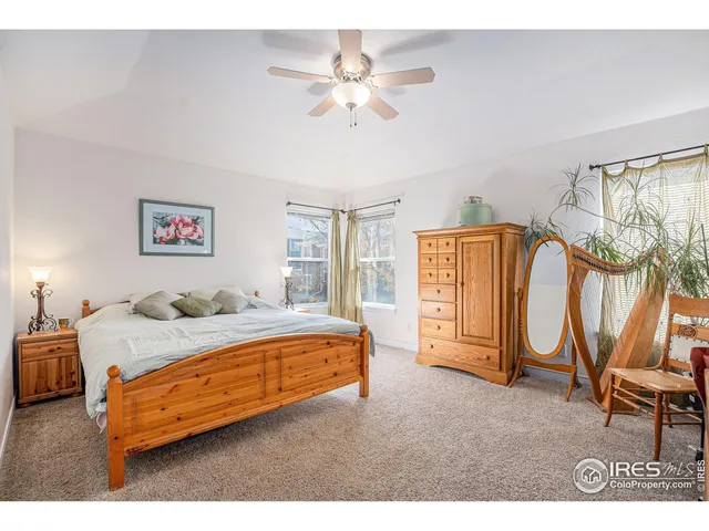 a bedroom with a bed a dresser with the potted plant on the dresser