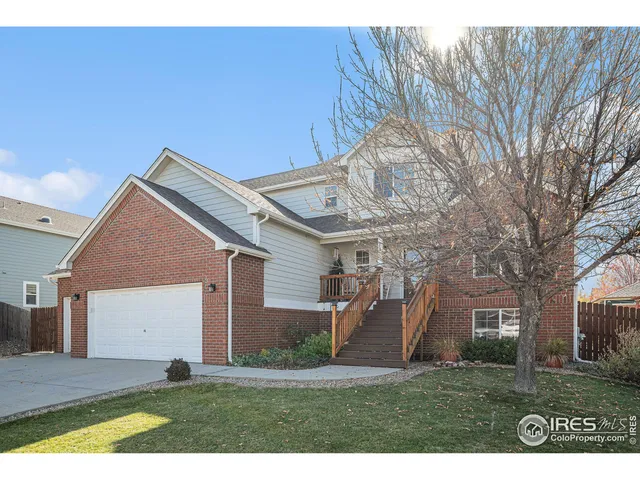 a view of a big house with a big yard and large tree