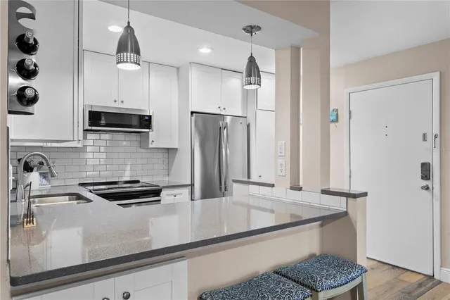 a kitchen with stainless steel appliances granite countertop a sink a stove and a refrigerator