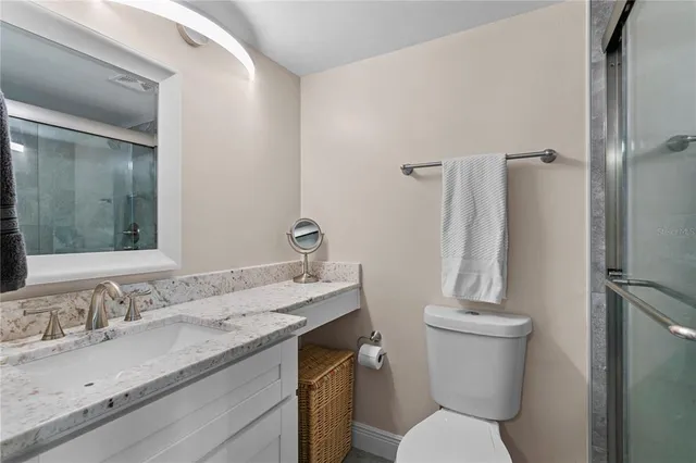 a bathroom with a granite countertop sink toilet and shower