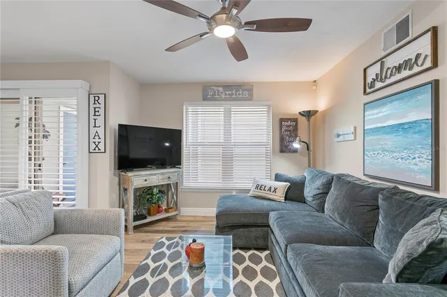 a living room with furniture a flat screen tv and a large window